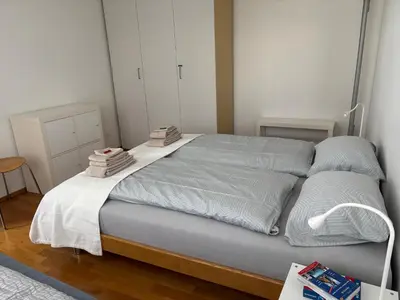 a bedroom with a large bed with white sheets at Appenzellerland, 2 Zimmer Ferienwohnung mit Aussicht in Haslen