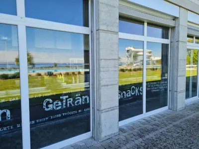 a store window with reflections of a golf course at Herberge Seeperle Bistro Rorschach in Rorschach