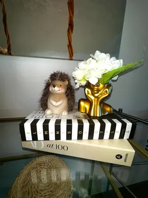 a stuffed animal and a vase with flowers on a glass table at Modern Lakeview Apartment in Romanshorn