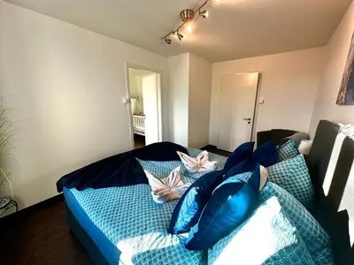 a bedroom with a blue bed with blue pillows at Modern Lakeview Apartment in Romanshorn