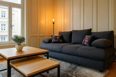 a living room with a tv on a dresser at OLMA Center Barrock Suites in St. Gallen