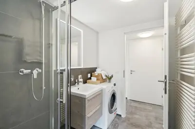 a bathroom with a sink and a washing machine at Klara 1014 - Olma, Spital, Uni St- Gallen in St. Gallen