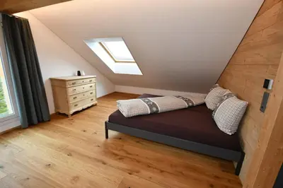 a attic bedroom with a bed and a skylight at Haus Ritzlisjokes in Weissbad