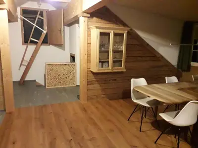 a dining room with a table and white chairs at Haus Ritzlisjokes in Weissbad