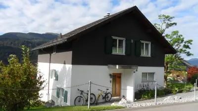a black and white house with two bikes parked outside at Wenk Elisabeth in Wildhaus