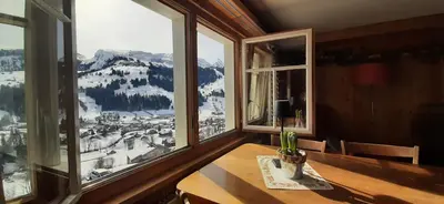 a dining room with a table and a view of a mountain at Ferienwohnung Toggilodge in Unterwasser