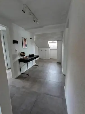 a hallway with a table in a white room at Bijou petit -mit Terrasse in Rorschach