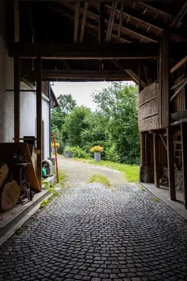 an open barn with a cobblestone road in the middle at Wohnhaus Münzmühle in Appenzell in Appenzell