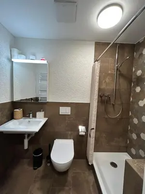 a bathroom with a toilet and a sink and a shower at S-Cape Suite&Spa in Horn