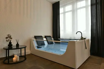 a glass desk with two chairs and a window at S-Cape Suite&Spa in Horn