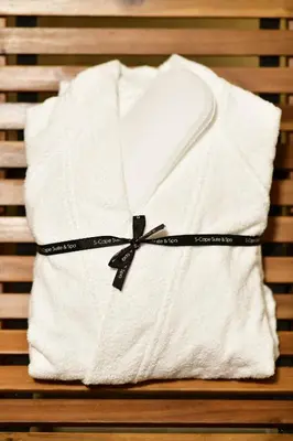 a white towel with a black bow on a bench at S-Cape Suite&Spa in Horn