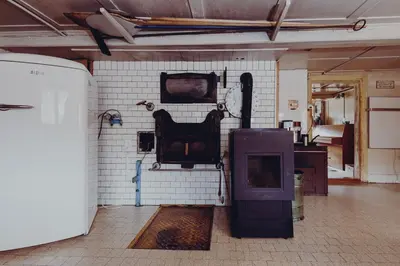 a room with a wall with a fireplace and a tv at Ferienhaus Lindeli, Luxeriös eifach in Sankt Peterzell