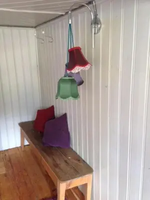 a room with a wooden bench with three hanging lights at Ferienhaus Lindeli, Luxeriös eifach in Sankt Peterzell