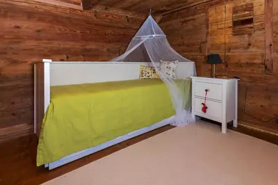 a bedroom with a bed with a mosquito net at Ferienhaus Lindeli, Luxeriös eifach in Sankt Peterzell