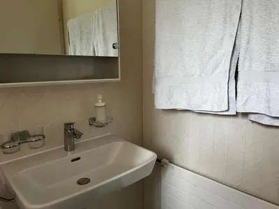 a bathroom with a sink and a mirror and towels at Zimmer am See in Goldach