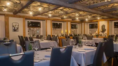 a dining room with tables and chairs with white table cloth at Hotel Badhof in Altstätten