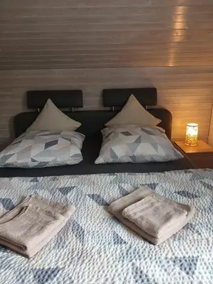 a bed with two towels on top of it at 2,5 Zimmer Ferienwohnung in Bühler, Nähe Appenzell in Bühler