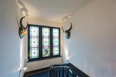 a dining room with chairs and a table and windows at Villa Philipp Plein - Designervilla mit Pool in Amriswil