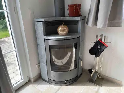 a fireplace in the corner of a room at Traumwohnung in 3 Minuten zum Bodensee in Dozwil