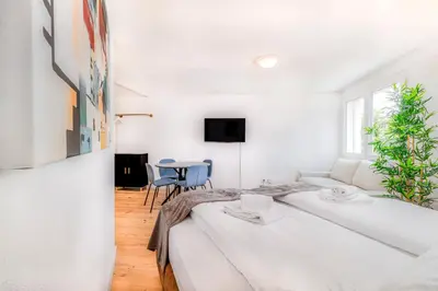 a white room with two beds and a table at VISIMO Apartments Teufenerstrasse St Gallen - Urban, Direct, Close to nature in St. Gallen