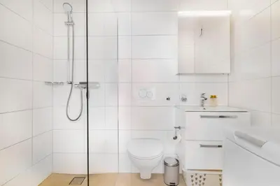 a white bathroom with a toilet and a shower at VISIMO Apartments Teufenerstrasse St Gallen - Urban, Direct, Close to nature in St. Gallen