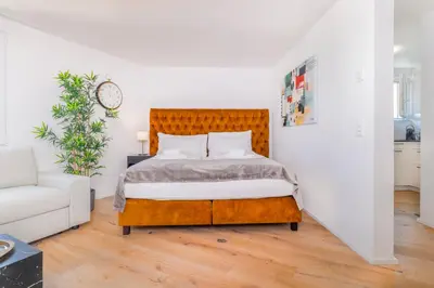 a bedroom with a bed and a couch at VISIMO Apartments Teufenerstrasse St Gallen - Urban, Direct, Close to nature in St. Gallen