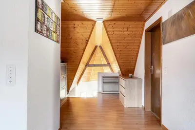 an attic kitchen with wooden ceilings and a wooden floor at Private Apartment in Degersheim