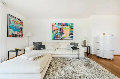 a white living room with a couch and a rug at DESIGN-APARTMENT 2 !Gratis parken, Free Parking! in Kreuzlingen