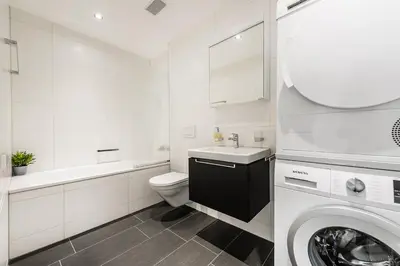 a white bathroom with a sink and a washing machine at DESIGN-APARTMENT 2 !Gratis parken, Free Parking! in Kreuzlingen