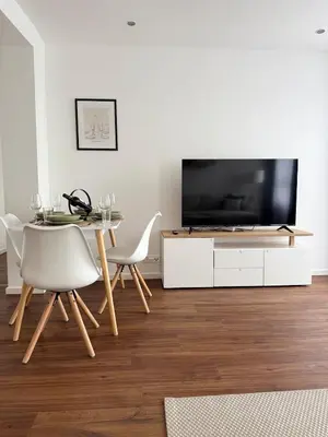 a wooden desk with a black chair and a drawer at Modern Apartment St Gallen Zentrum in St. Gallen