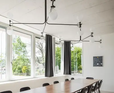 a dining room with a table and chairs and windows at Gästehaus Meiersegg - HotelFlawil in Flawil
