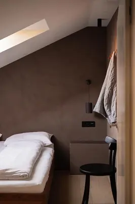a bedroom with a bed and a table and a chair at normalkonsum - premium apartments in St. Gallen