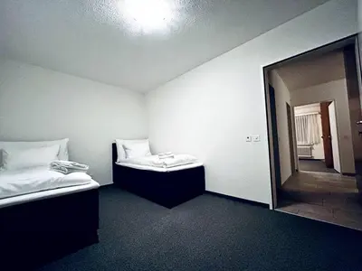 an empty room with two beds and a mirror at Gemütliches und geräumiges Apartment für Familien und Gruppen mit Seeblick in Heiden