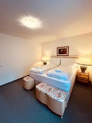 a bedroom with a bed with two ottomans at Gemütliches und geräumiges Apartment für Familien und Gruppen mit Seeblick in Heiden