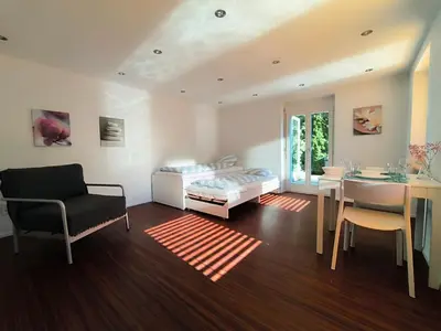a living room with a bed and a dining room at Charmantes Studio in Teufen in Teufen