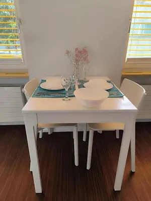 a white table with chairs and plates and glasses on it at Charmantes Studio in Teufen in Teufen