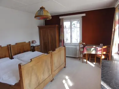 a bedroom with two beds and a table and a window at Park in Heiden