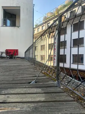 a bridge over a boardwalk in front of a building at Kugelgasse Apartments - Smart Living by Klang und Kleid in St. Gallen