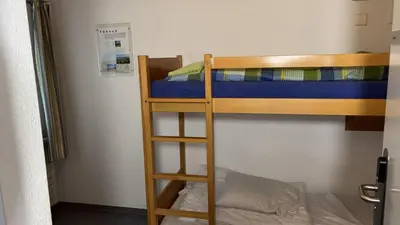 a bunk bed with a ladder next to a bunk bed at Herberge Seeperle Bistro Rorschach in Rorschach