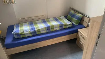 a small bed in a small room with two pillows at Herberge Seeperle Bistro Rorschach in Rorschach