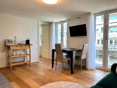 a living room with a table and chairs and a television at Klara 1011 - Olma, Spital, Uni St- Gallen in St. Gallen