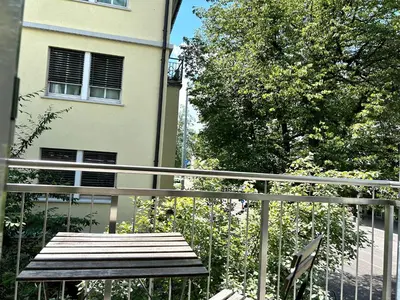 a wooden bench on a balcony in front of a building at Klara 1011 - Olma, Spital, Uni St- Gallen in St. Gallen