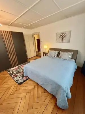 a bedroom with a blue bed and a wooden floor at Zimmer mit Gemeinschaftsbad in Arbon