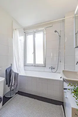 a white bathroom with a tub and a sink at Zimmer mit Gemeinschaftsbad in Arbon