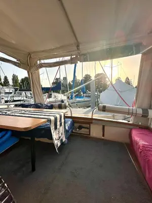 a boat with a red umbrella sitting in the water at Gemütliches Motorboot im Yachthafen von Romanshorn in Romanshorn