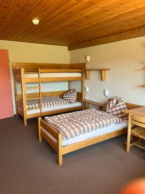 two bunk beds in a room with a wooden ceiling at Mattenhof in Flawil