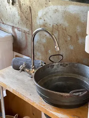 a metal sink with a faucet on a counter at Charmante Bungalows mit Traumaussicht in Wienacht-Tobel