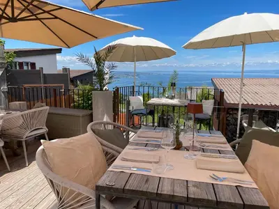 a wooden table with chairs and umbrellas on a patio at Charmante Bungalows mit Traumaussicht in Wienacht-Tobel