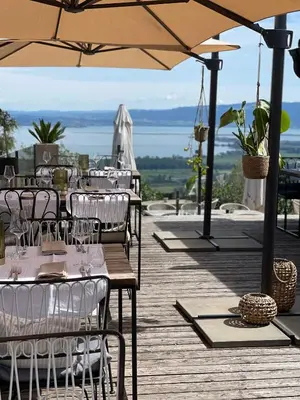 a restaurant with tables and chairs and an umbrella at Charmante Bungalows mit Traumaussicht in Wienacht-Tobel