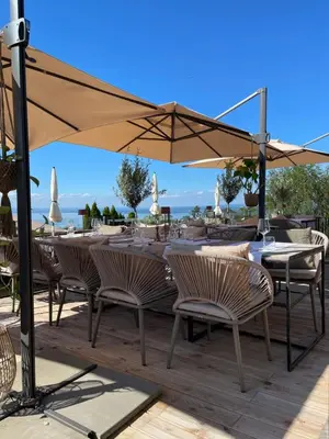a table and chairs under an umbrella on a deck at Charmante Bungalows mit Traumaussicht in Wienacht-Tobel